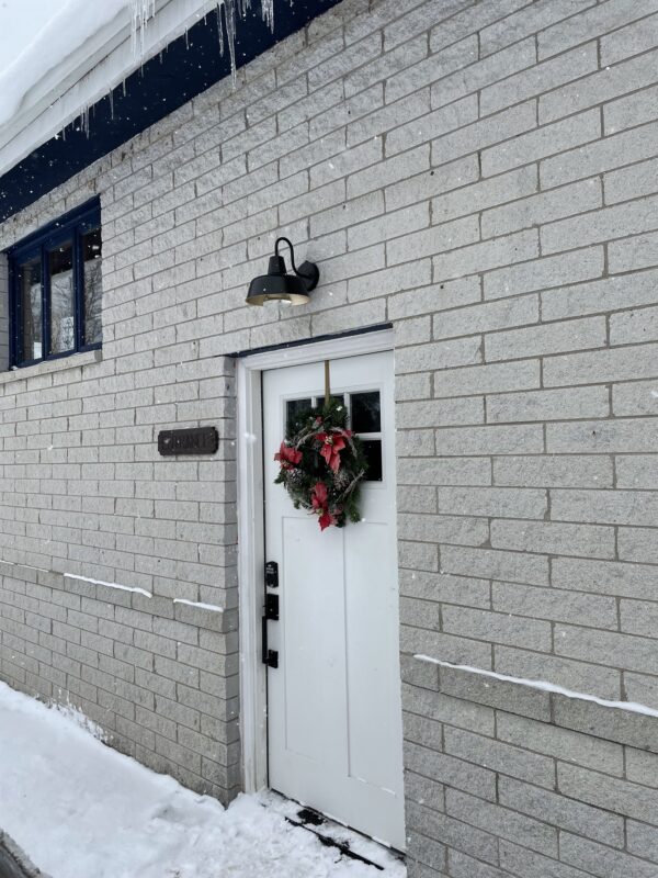 A white door with a Christmas wreath