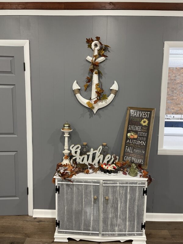 A gray wall with an anchor decor and other trinkets